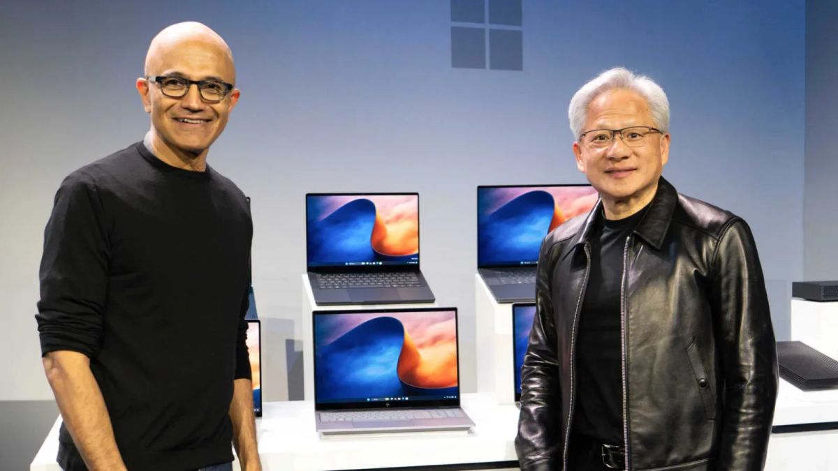 Satya Nadella and Jensen Huang beside a display of Windows laptops